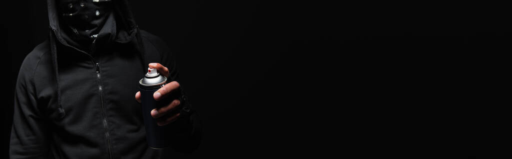 Vue recadrée d'un hooligan afro-américain tenant de la peinture en aérosol isolée sur du noir, bannière  - Photo, image