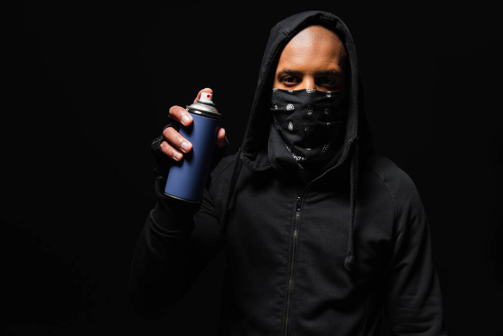 African american hooligan with bandana on face holding spray paint isolated on black  - Foto, Imagem
