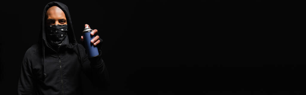 Αφρικανική αμερικανική χούλιγκαν με σκοτεινό πρόσωπο κρατώντας σπρέι μπογιά απομονώνονται σε μαύρο, πανό  - Φωτογραφία, εικόνα