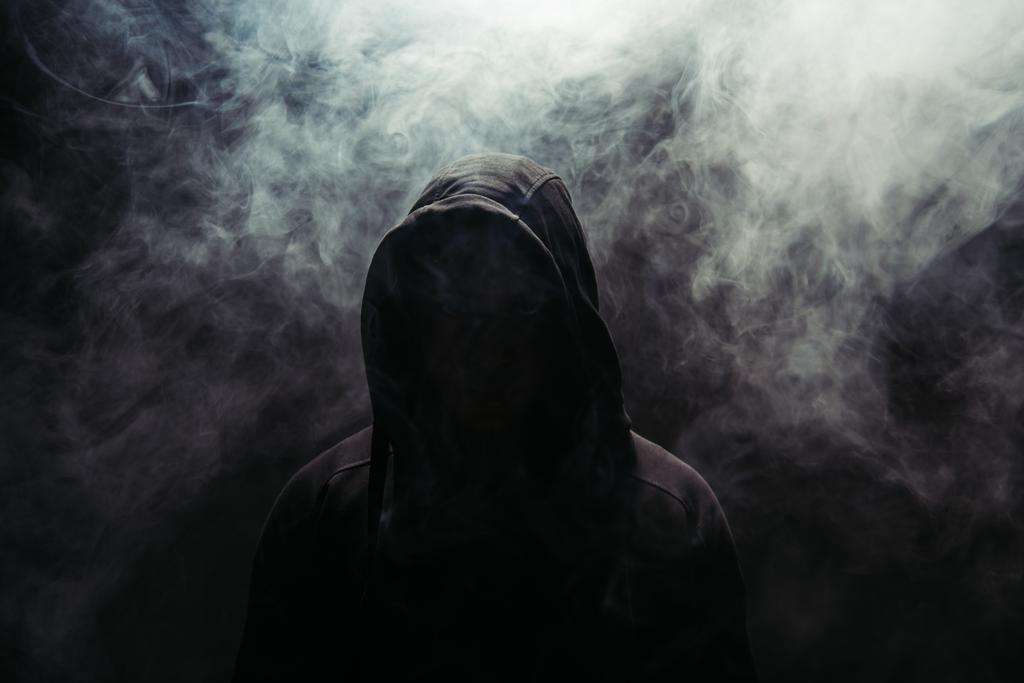 Silhouette of hooligan on black background with smoke  - Fotografie, Obrázek