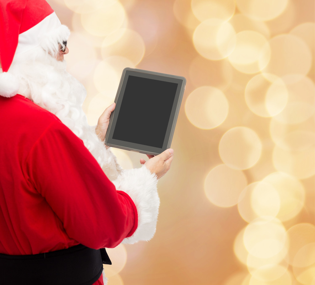 Mann im Weihnachtsmannkostüm mit Tablet-PC - Foto, Bild