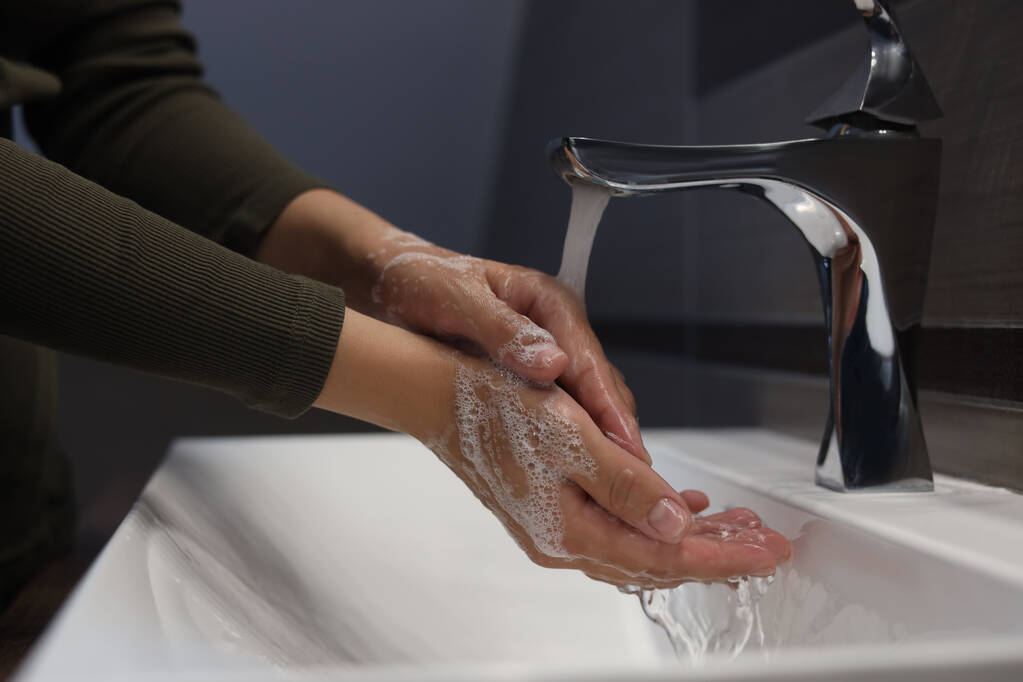Женщина моет руки в ванной комнате, вид крупным планом - Фото, изображение