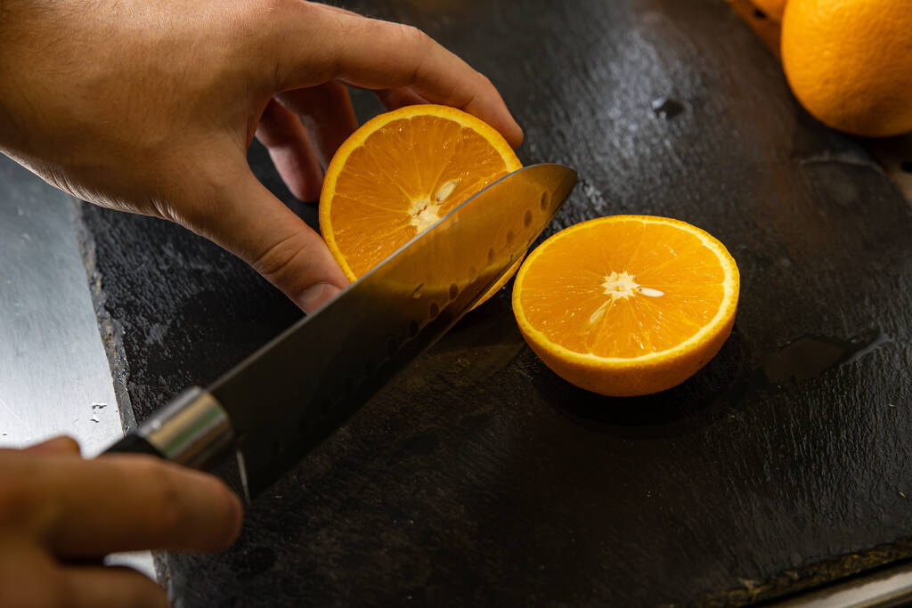 fresh orange slices with knife on wooden background - 写真・画像