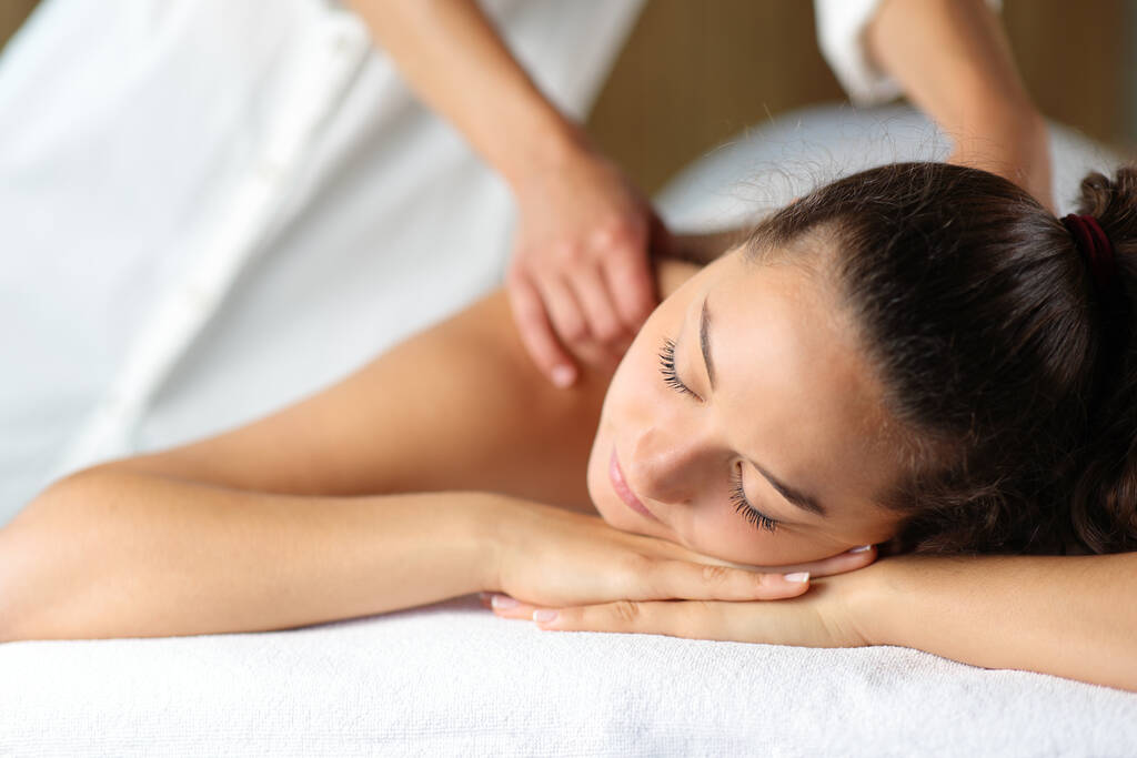Mulher relaxante com os olhos fechados e terapeuta massageando-a no spa - Foto, Imagem