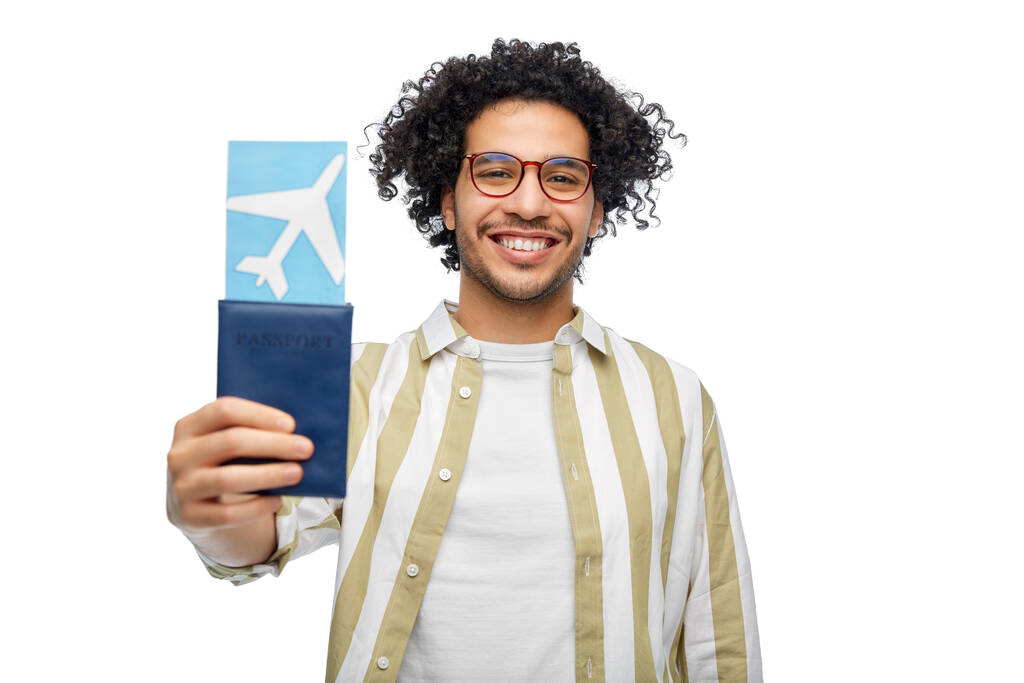 utazás, turizmus és az emberek koncepció - mosolygós ember útlevéllel és repülőjegy fehér háttér - Fotó, kép
