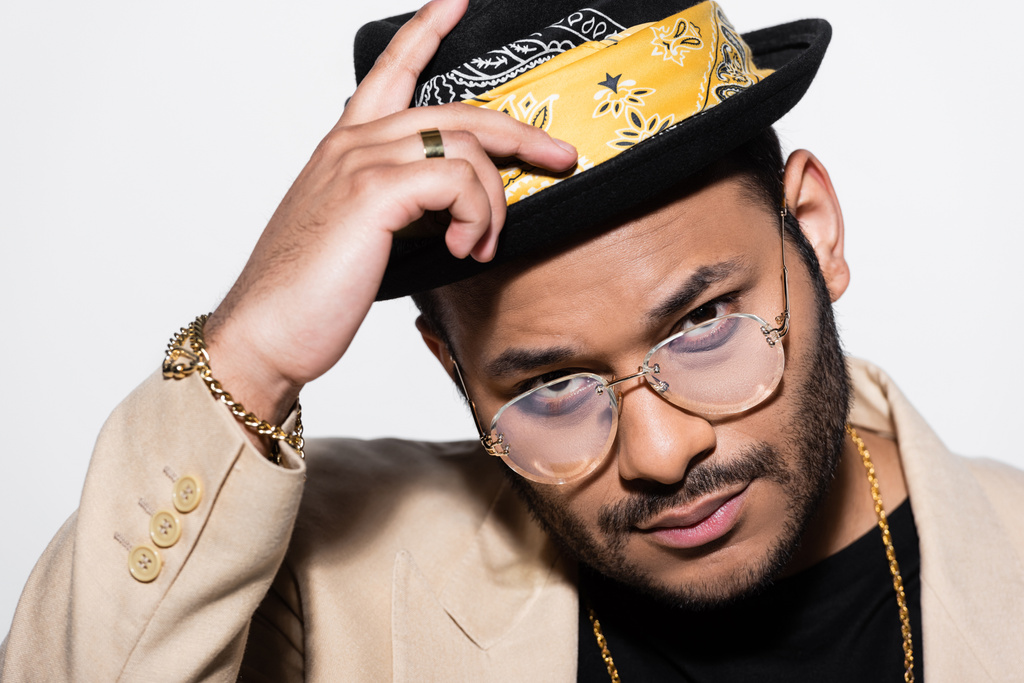 Porträt des östlichen Hip-Hop-Sängers mit Brille und Fedora-Hut isoliert auf grau - Foto, Bild