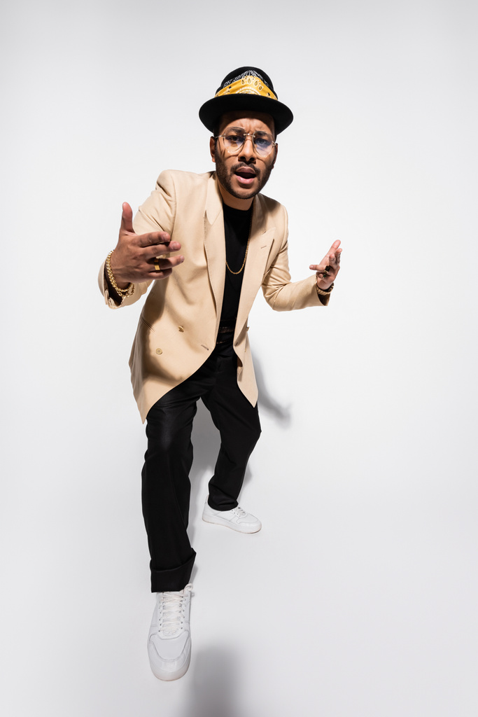 Fötr şapkalı ve gözlüklü havalı bir doğulu hip hop sanatçısı. - Fotoğraf, Görsel