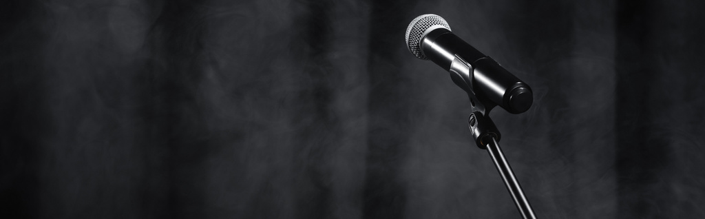 microphone on stand on black stage with curtain and smoke, banner - Foto, imagen