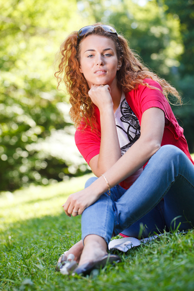 γυναίκα που κάθεται στο γρασίδι στο πάρκο - Φωτογραφία, εικόνα