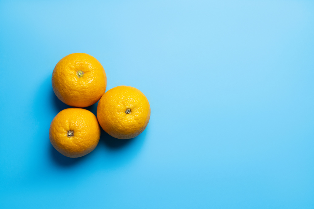 Вид сверху на апельсины на синем фоне с пространством для копирования - Фото, изображение