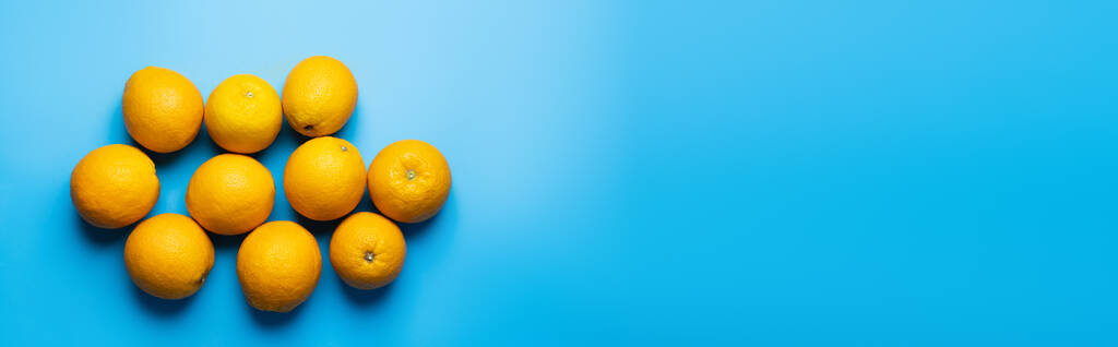 Vue du dessus des oranges mûres sur fond bleu avec espace de copie, bannière  - Photo, image