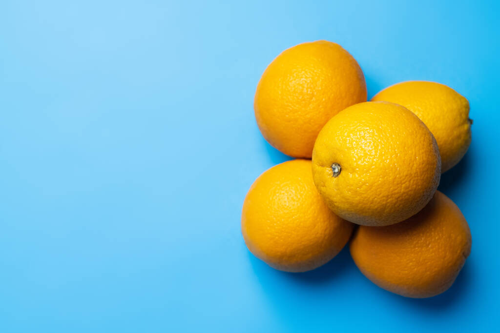 Top view of bright oranges on blue background with copy space - Photo, image