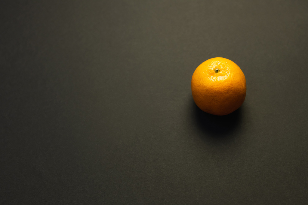 High angle view of bright tangerine on black background - Foto, afbeelding
