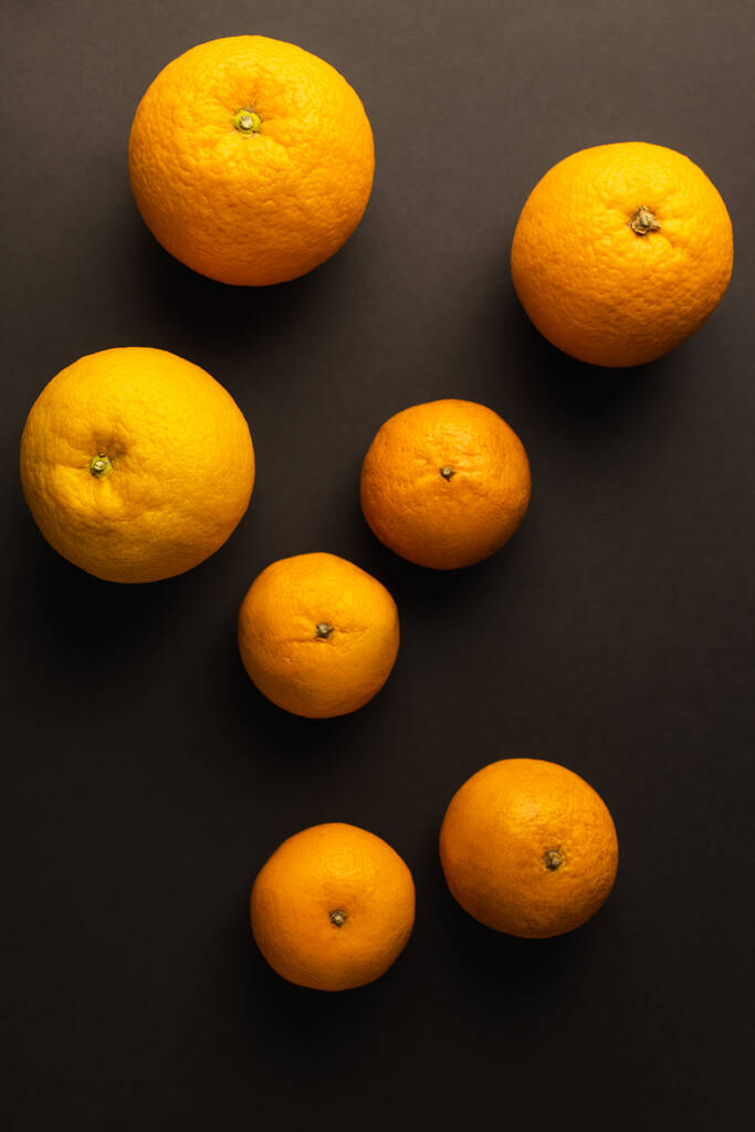 Top view of bright citrus fruits on black background - Foto, Imagen