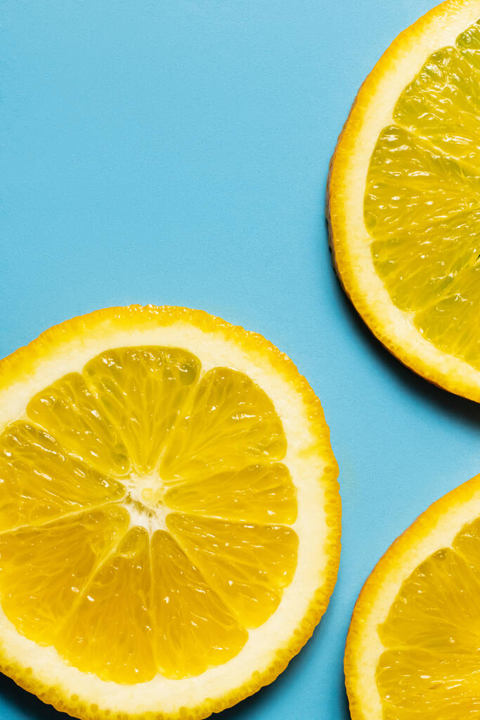 Close-up weergave van organische sinaasappelschijfjes op blauwe achtergrond - Foto, afbeelding