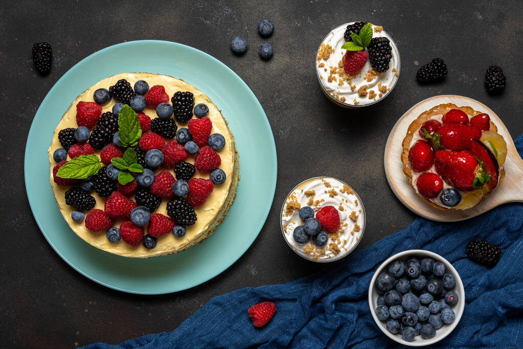 Homemade cake with fresh berries and sweet desserts on dark background.  - Photo, Image