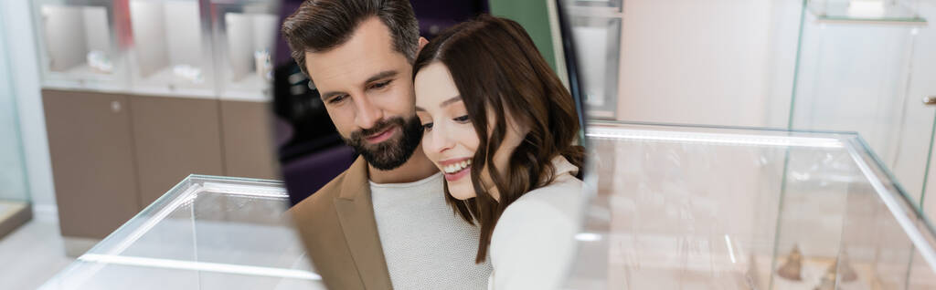 Positive couple reflecting in mirror in jewelry store, banner  - Foto, imagen