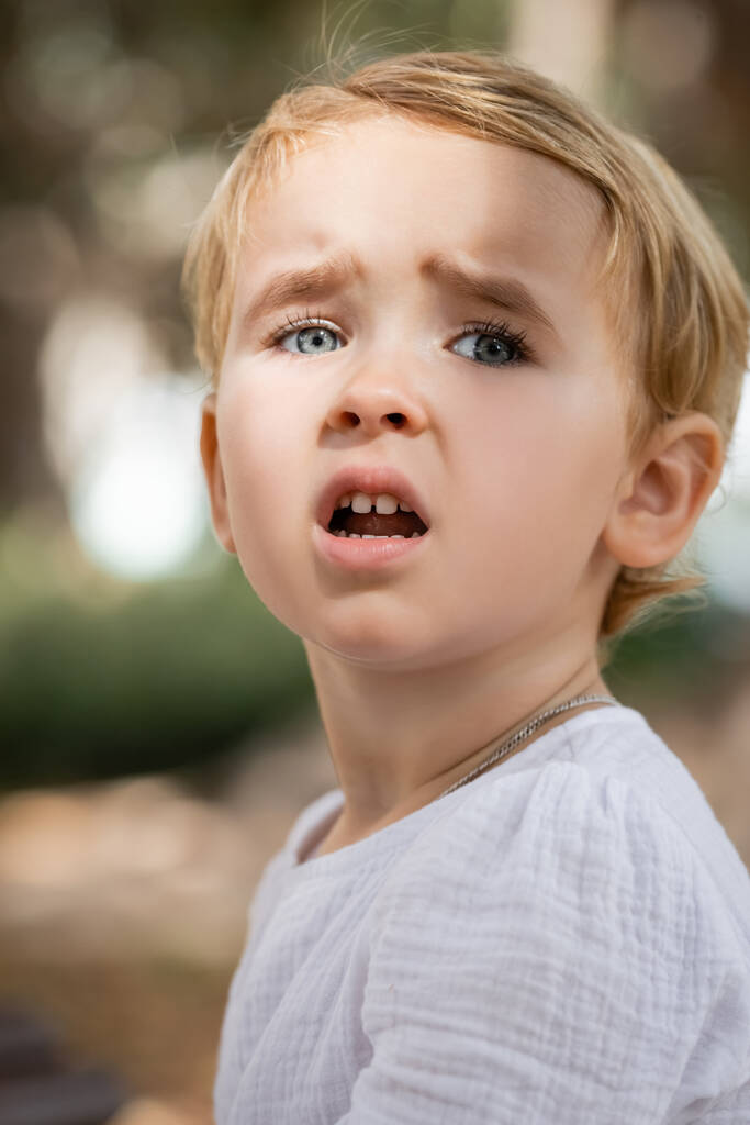 Portrait of sad toddler girl looking away outdoors  - Foto, afbeelding