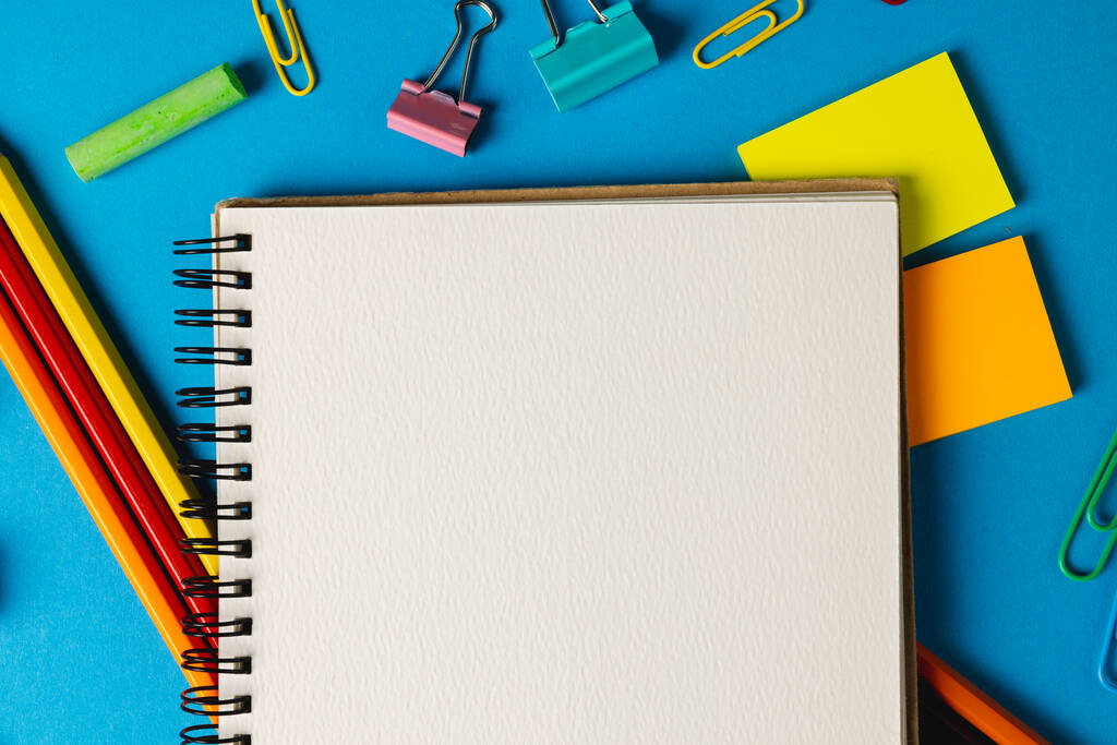 Composición de material escolar con cuaderno con espacio para copias en superficie azul. Equipo escolar, herramientas y concepto de creatividad. - Foto, imagen