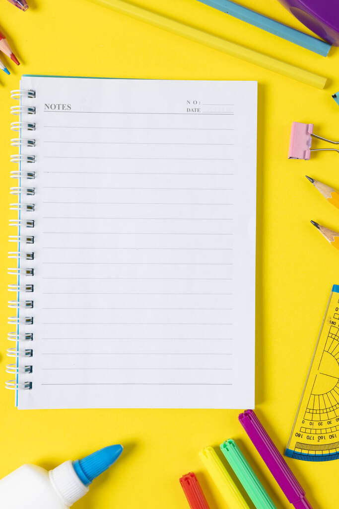 Imagine of various office supplies and plastic utensils, notebook, crayons on yellow background. Education, learning and creativity. - Foto, immagini