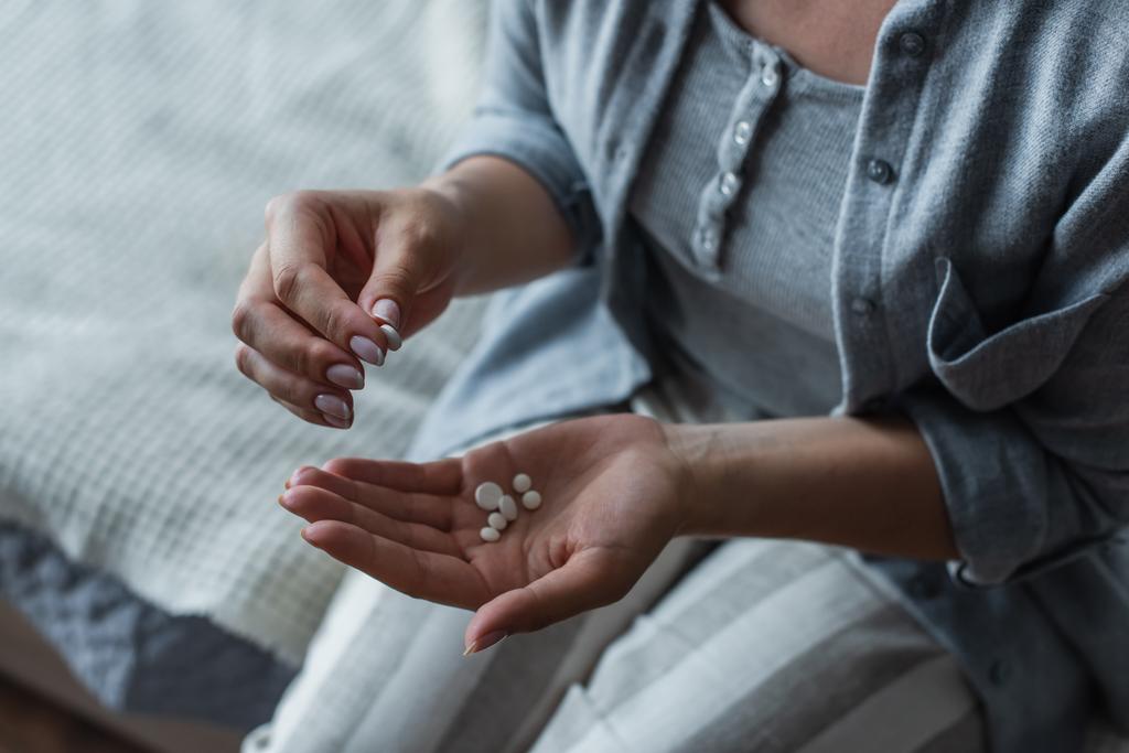 vista ritagliata di donna con menopausa tenendo pillole in mano - Foto, immagini
