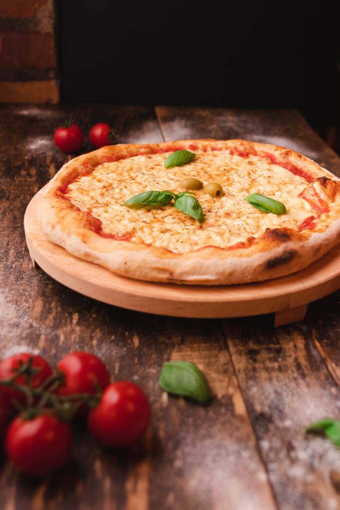 Pystysuora laukaus maukasta ja rapeaa pizzaa vihanneksilla ja kirsikkatomaateilla puupöydällä - Valokuva, kuva