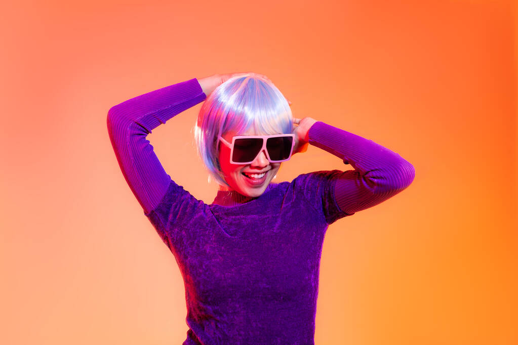 Concept de fille Cyber punk, femme asiatique en sweat-shirt violet argent et bleu style cheveux courts portant des lunettes de soleil posant la danse comme un robot. - Photo, image