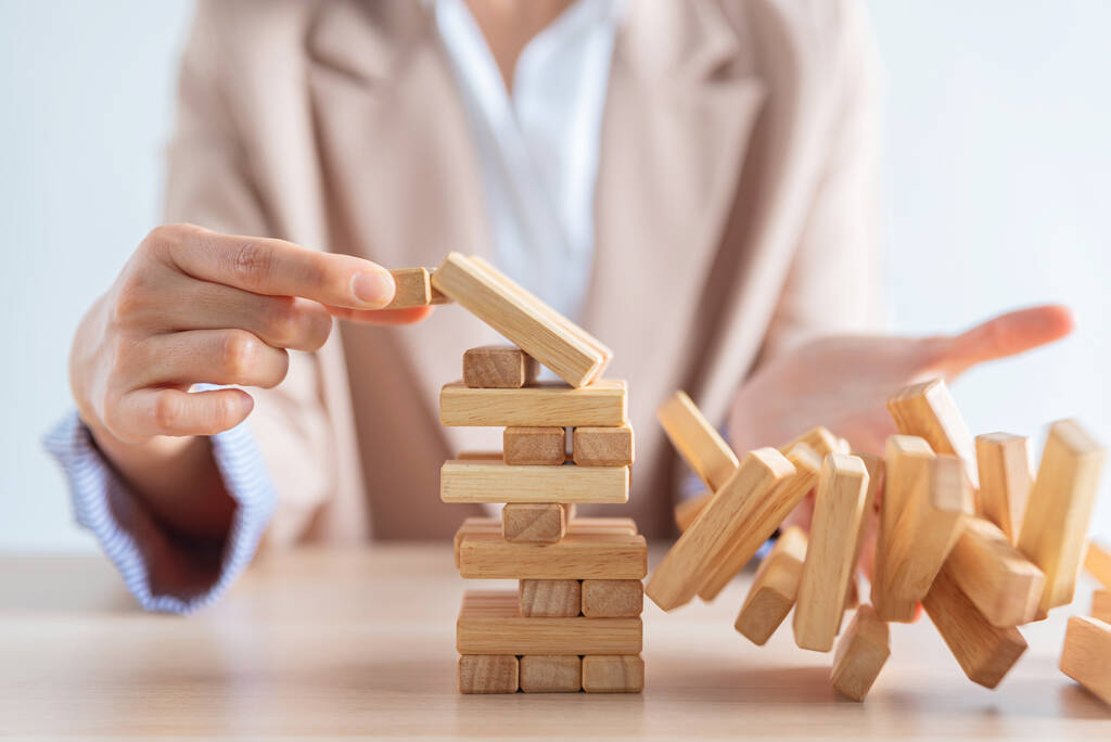 business female hand building a wooden block tower but failed , risk and strategy of project management , business and strategy concept - Photo, Image