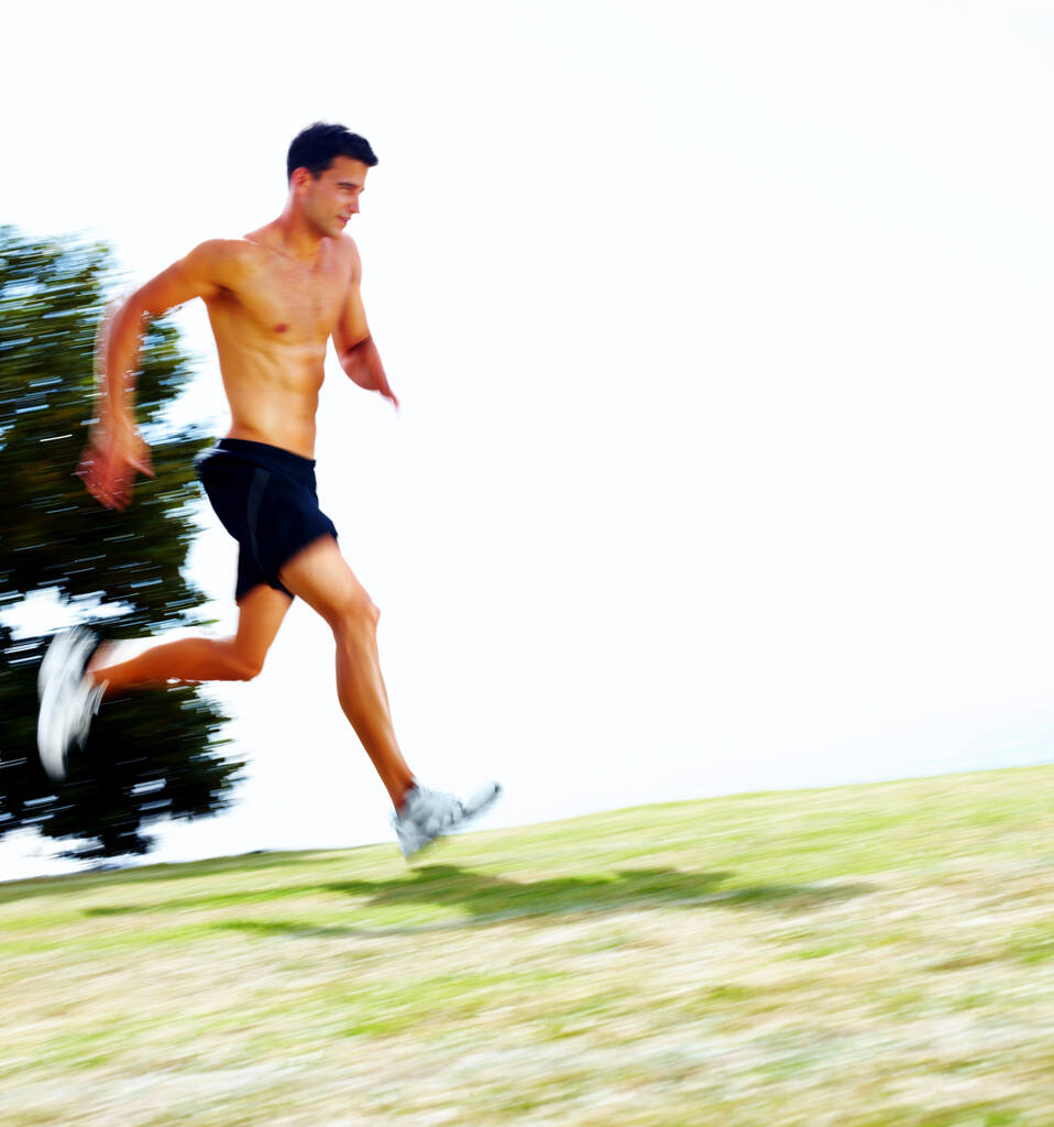 Portrait of a muscular young man running outdoors - Copyspace. - 写真・画像
