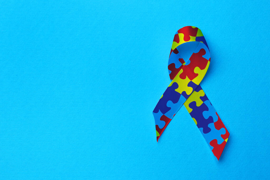 World Autism Awareness Day. Colorful puzzle ribbon on turquoise background, top view with space for text - 写真・画像