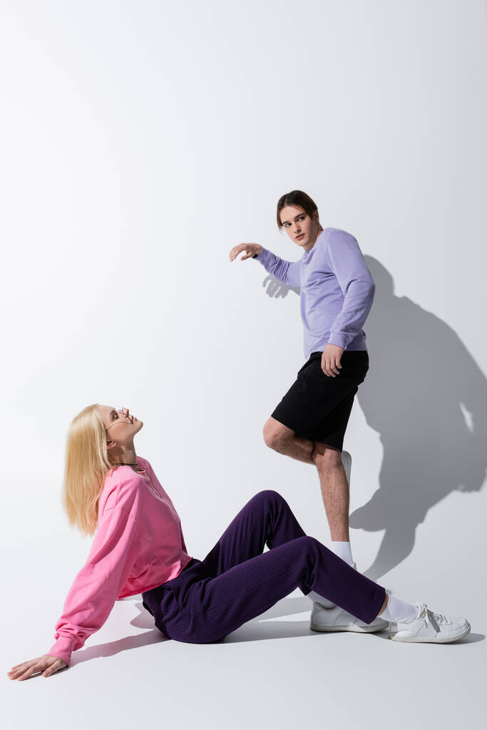 Plná délka stylového mladého páru pózujícího na šedém pozadí se stínem  - Fotografie, Obrázek