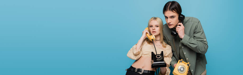 Stylish models talking on telephones on blue background, banner  - Foto, afbeelding