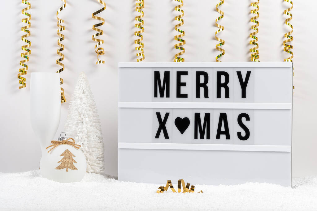 Christmas decor and lightbox with text MERRY XMAS on a table with snow. Minimal Christmas or New Year holiday concept. - Φωτογραφία, εικόνα