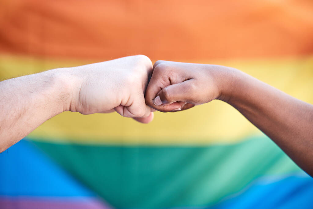 two protestors bumping fists in support at a LGBTQ protest. - 写真・画像