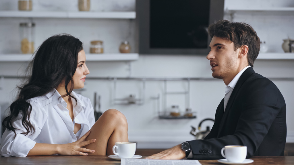 businessman talking with smiling girlfriend in white shirt near cups of coffee - Φωτογραφία, εικόνα