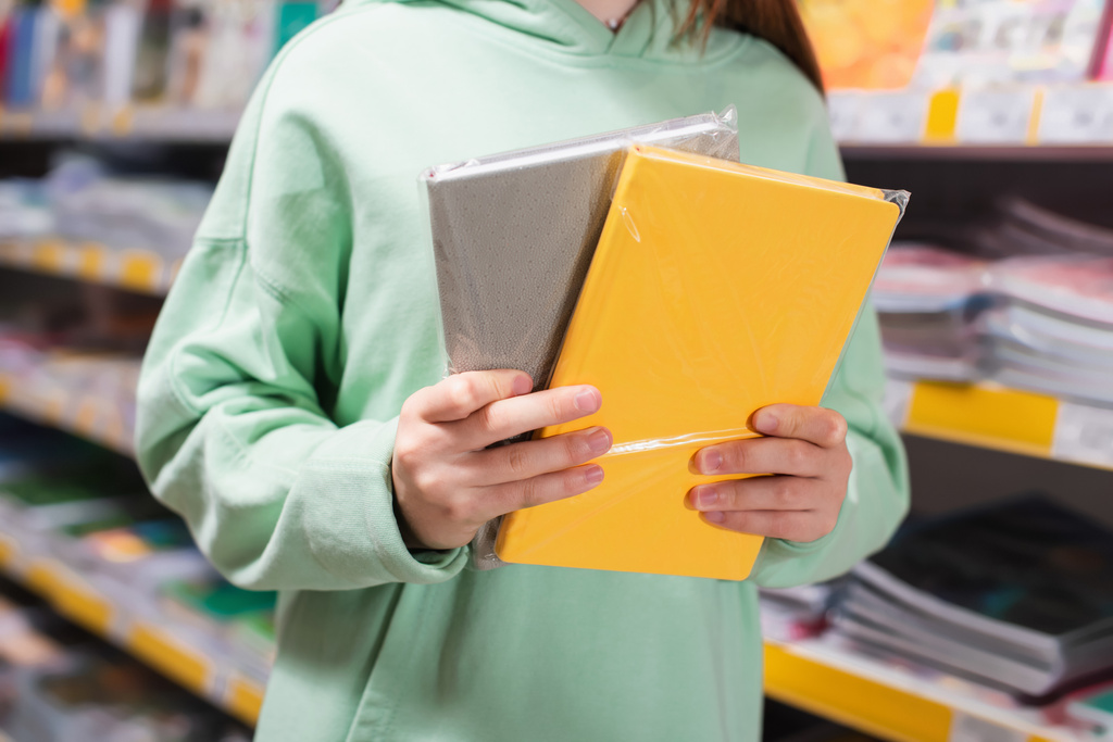 visão parcial da criança com blocos de notas coloridos na loja de artigos de papelaria - Foto, Imagem