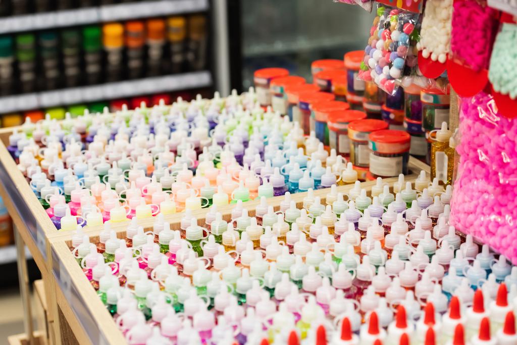 glue and paints near push pins in stationery store - Foto, Bild