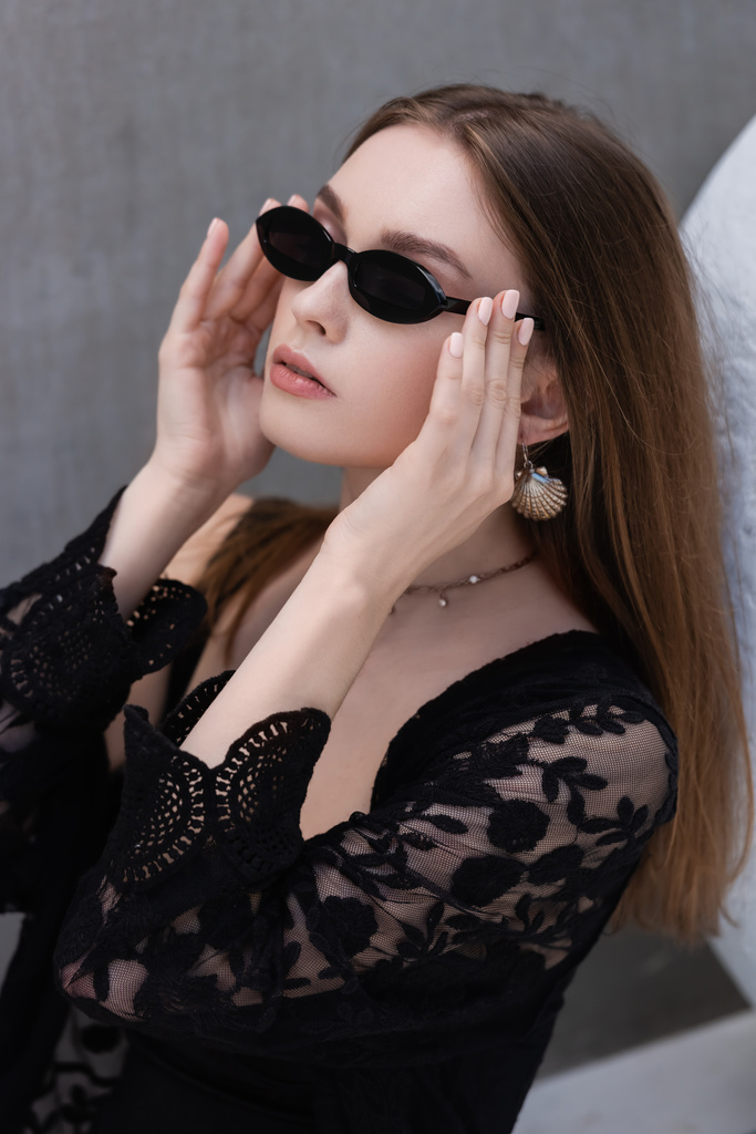 Portrait of young woman in guipure robe wearing sunglasses at resort  - Photo, Image