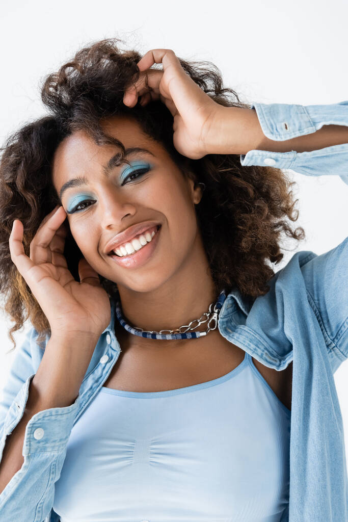 happy african american woman with blue eye shadows and perfect skin isolated on white - 写真・画像
