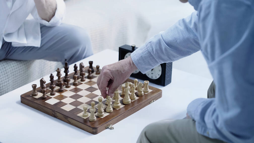 обрізаний вид на старших шахістів, які грають вдома
 - Фото, зображення