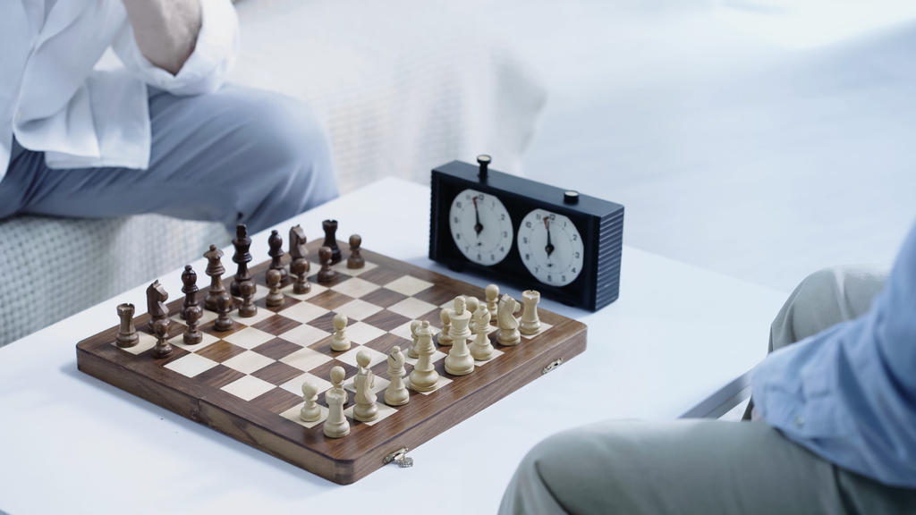chessboard with figures near timer and cropped senior men - Foto, Bild