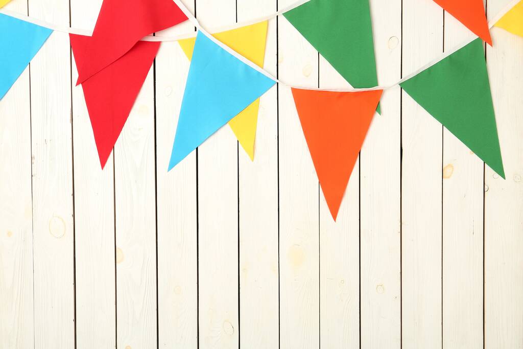 Buntings with colorful triangular flags on white wooden background. Space for text - 写真・画像
