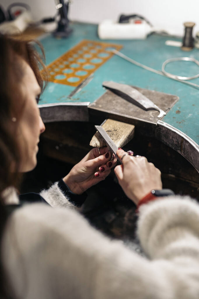 Concentrated adult woman working in jewelry workshop. - Foto, Imagem