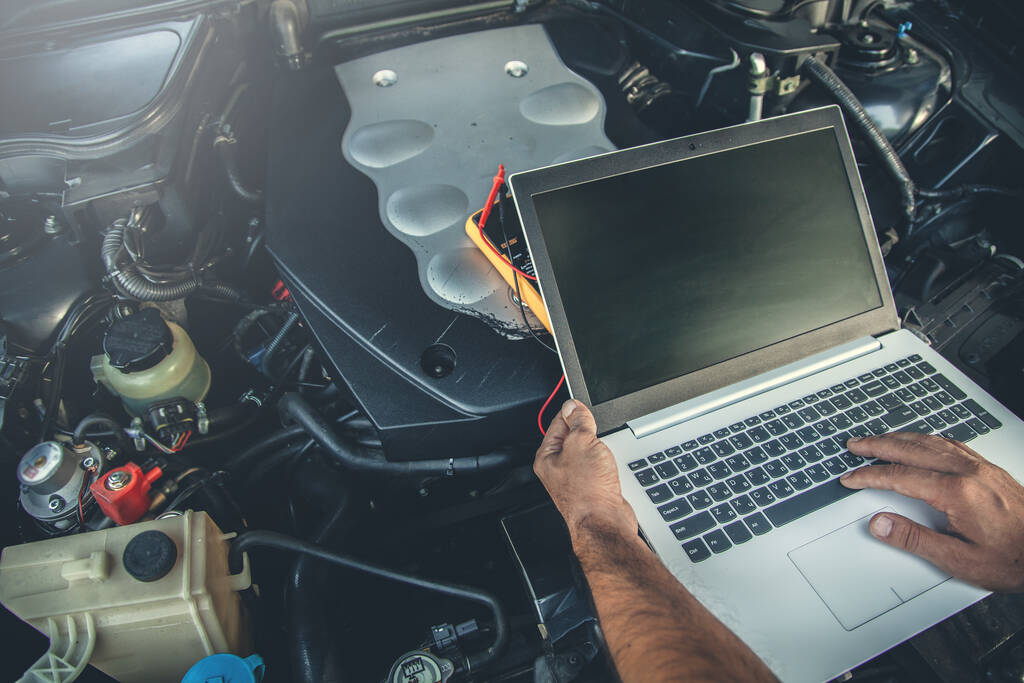 man to repair car with hand computer - Foto, Bild