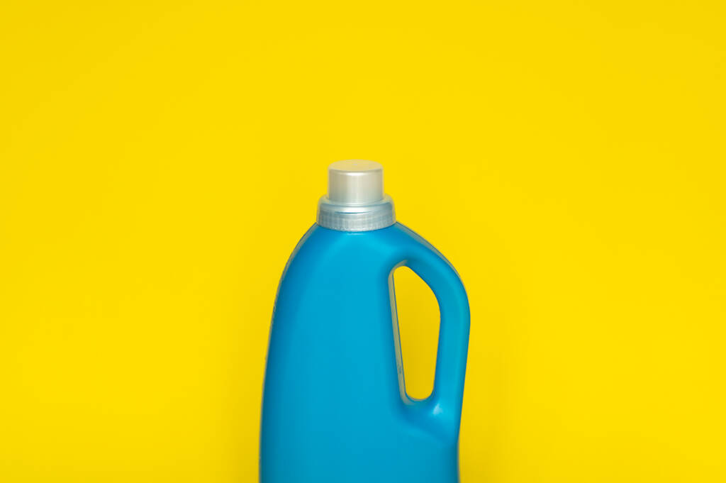 Blaue Plastikflasche mit grauem Verschluss auf gelbem Hintergrund für flüssige Wasch- oder Reinigungsmittel. Verpackungsvorlage-Attrappe - Foto, Bild