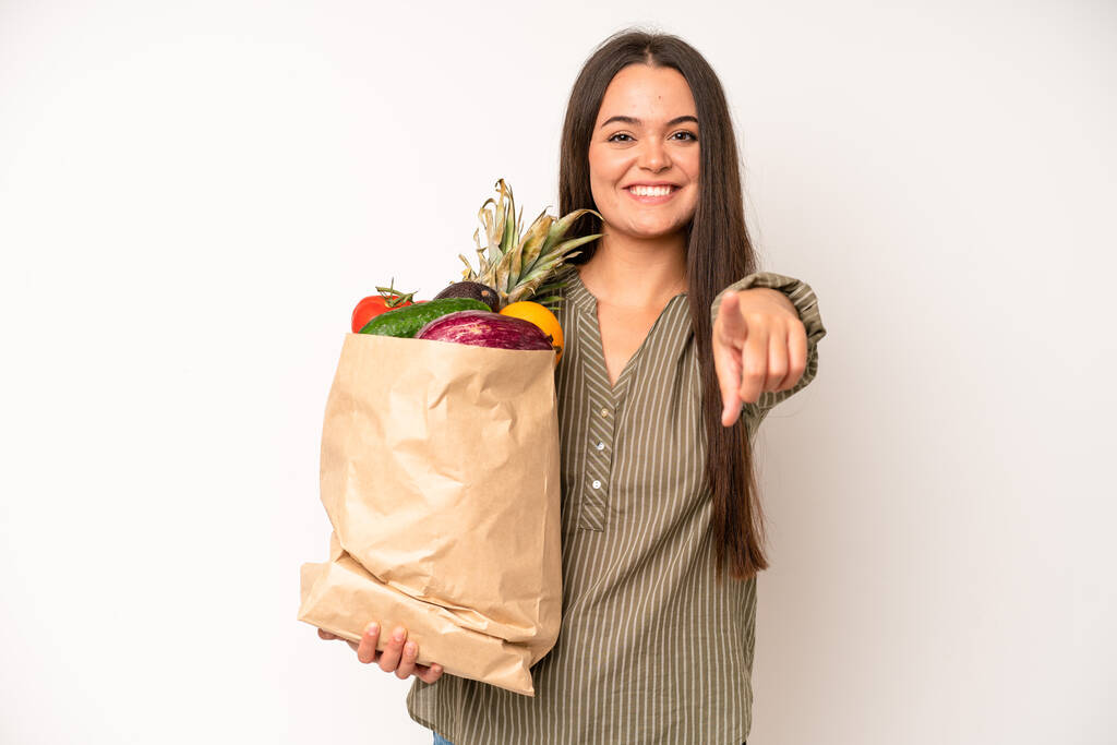 hispanic pretty woma smiling cheerfully, feeling happy and showing a concept. market vegetables bag concept - 写真・画像