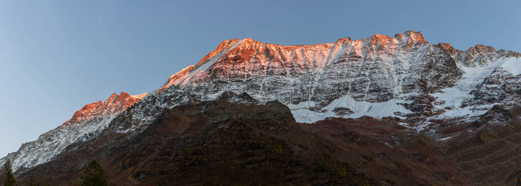 Панорамний вид Альпглоу помаранчевий захід світла на сніговому гірському хребті у Вале. Lonzahoerner, Breithorn and Breitlauwihorn. - Фото, зображення