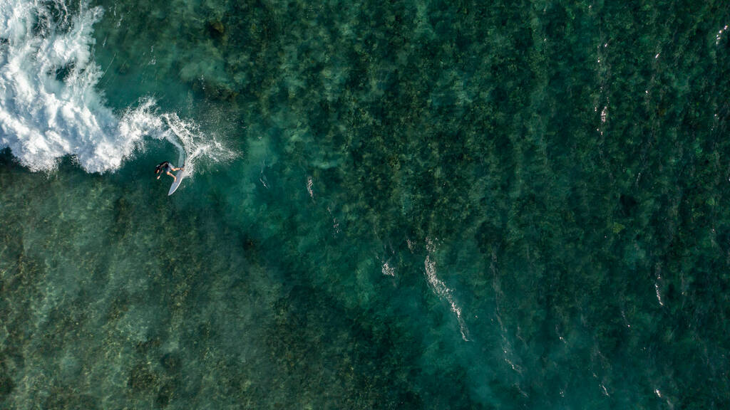 Una vista aérea de un surfista masculino montando las enormes olas - Foto, Imagen