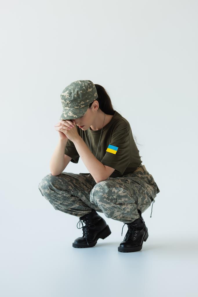 Disappointed soldier with ukrainian flag on chevron on grey background - Foto, Bild
