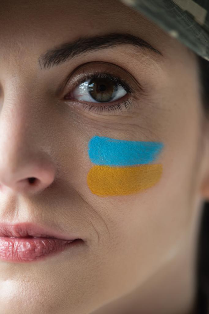 close up view of cropped woman with ukrainian flag painted on face - Foto, Imagem